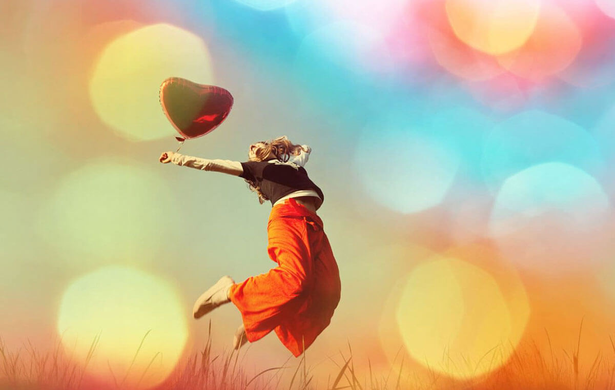 Frau springt mit Ballon